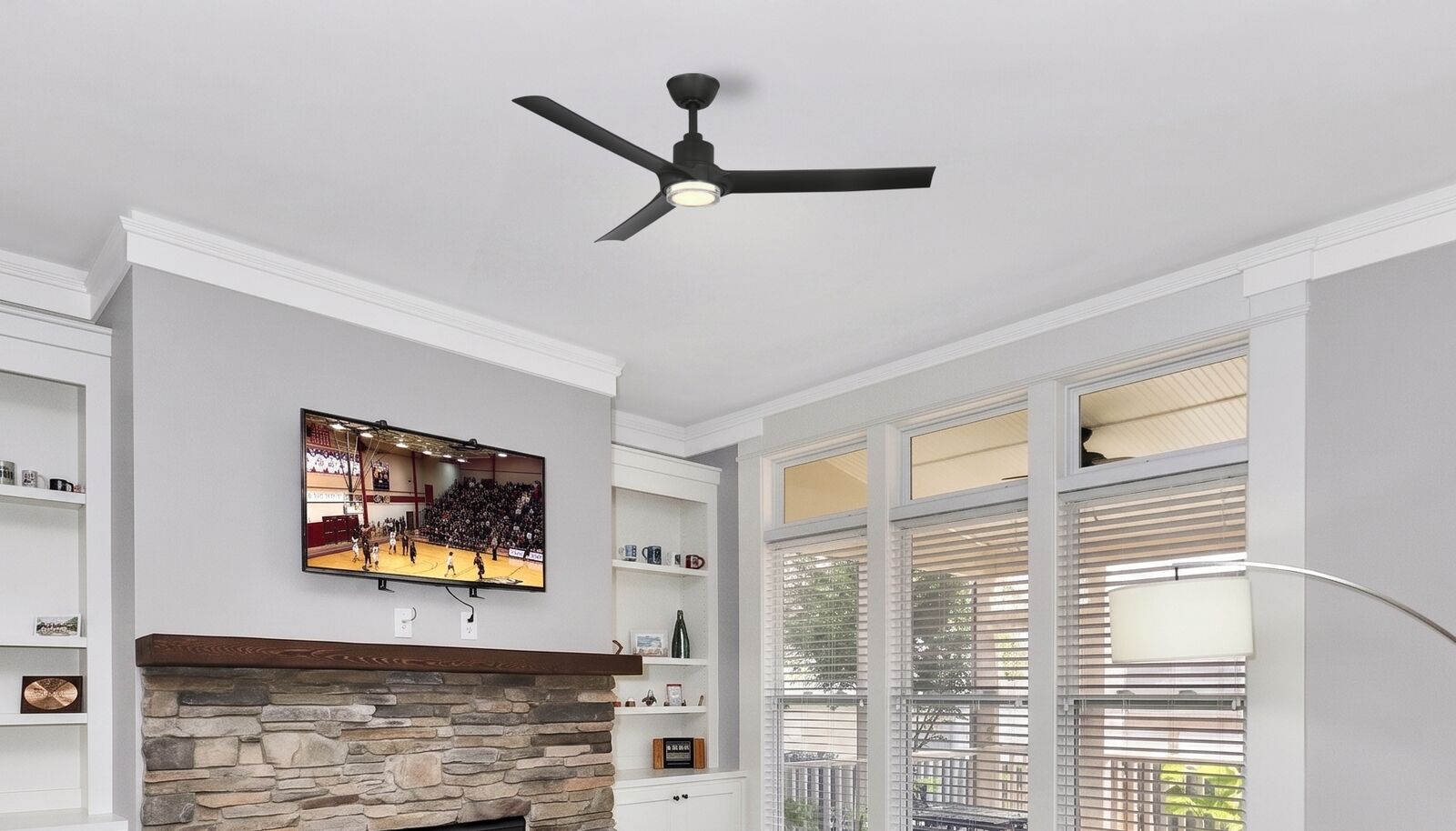 A GoGo ceiling fan lit at dusk in the great room of an American home